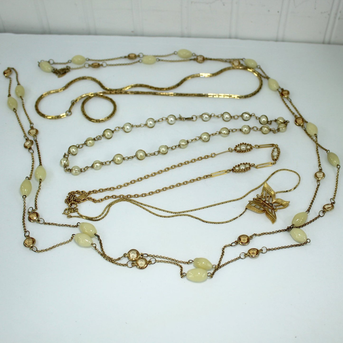 Lot Collection 25 Vintage Designer Signed Jewelry Necklaces Bracelets Pins Earrings necklaces on table closeup