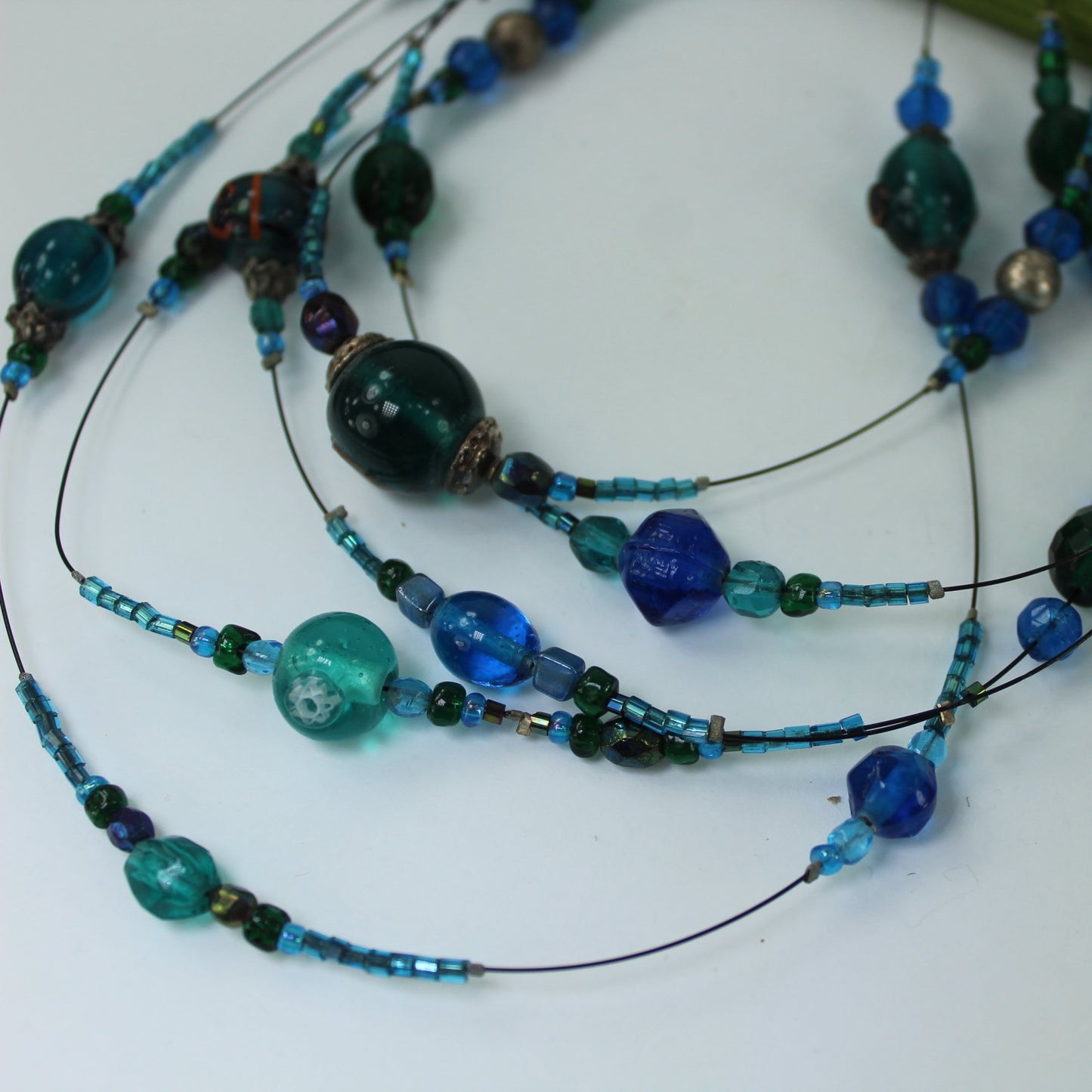 Shiny Iridescent Beads 5 Strand Wire Necklace Shades Blue Turquoise closeup of beads