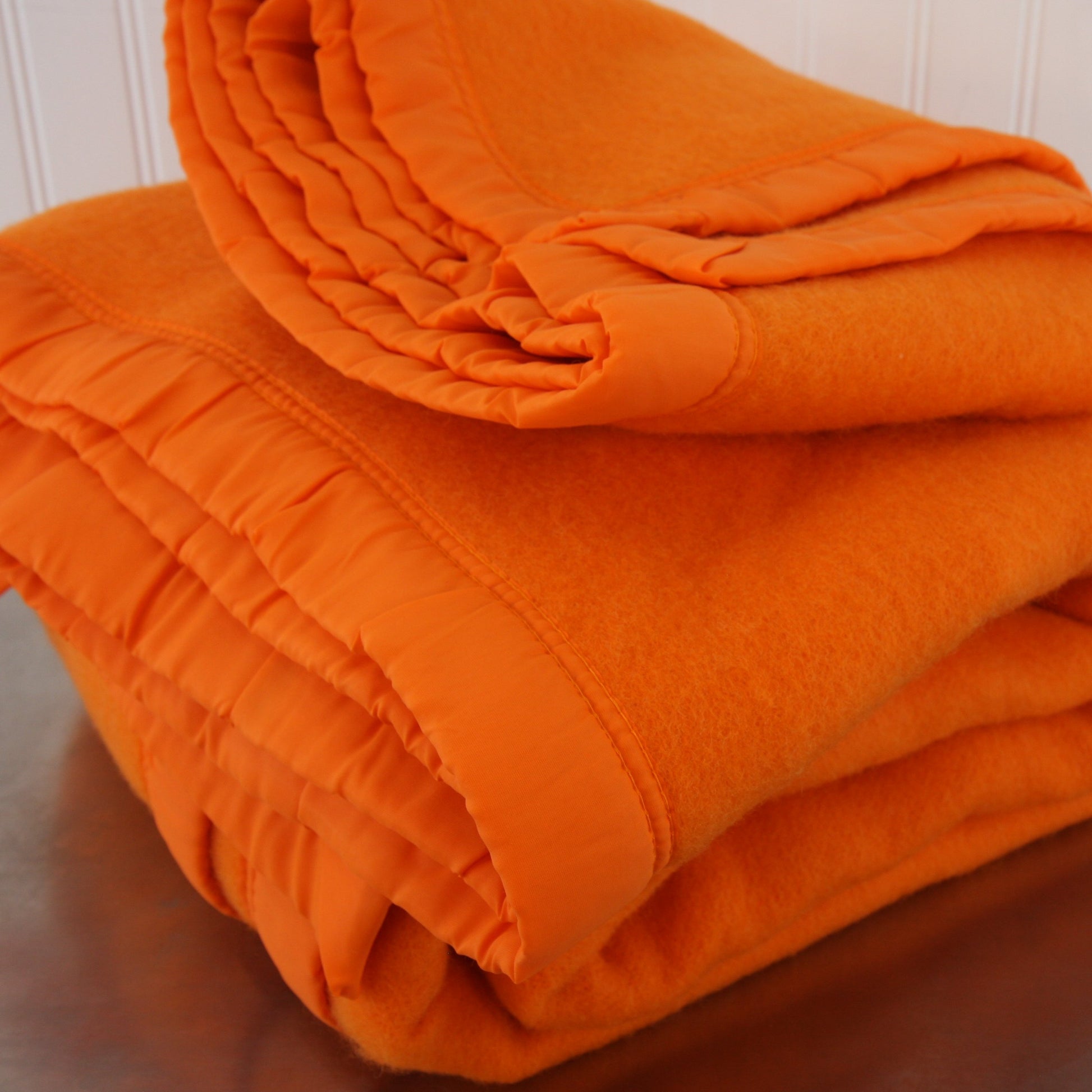 Folded Riviera Manta Acrylic Orange Blanket Front View Bindings