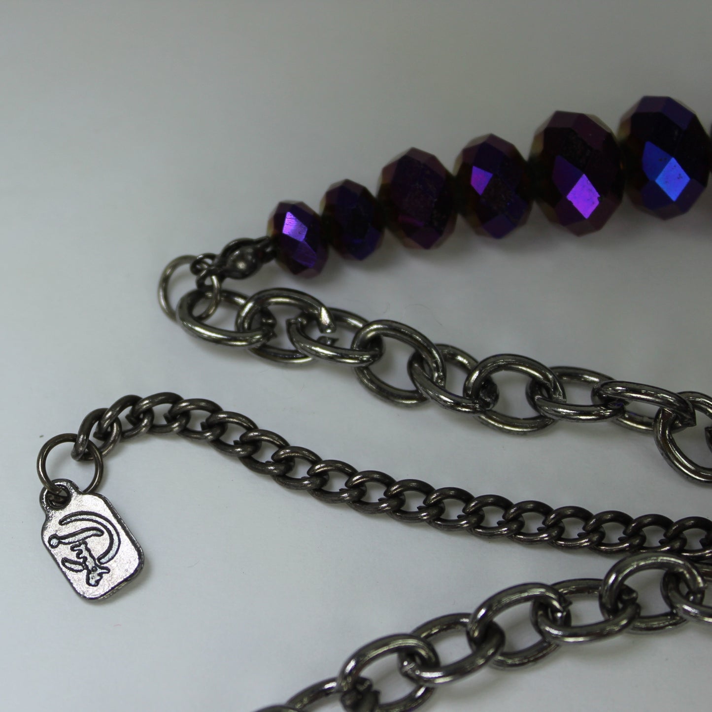 Designed signed Necklace Amethyst Crystal & Iridescent Cut Beads Alive with Sparkle closeup of metal maker tag looks like scotty dog